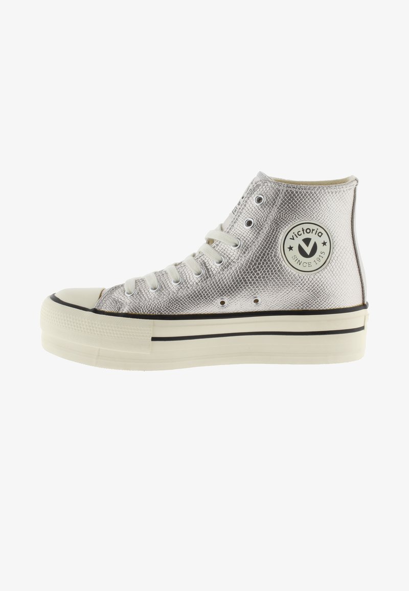 Baskets montantes argentées avec surface texturée, lacets blancs, semelle en caoutchouc et logo rond "Victoria Since 1915" sur le côté.