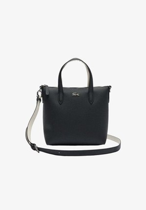 Sac à main en cuir noir texturé avec deux poignées supérieures, logo argenté sur le devant et bandoulière longue amovible.