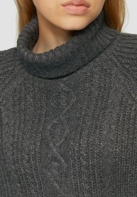 Ciemnoszary dzianinowy sweter z golfem, o fakturowanym wzorze z detalami w formie warkoczy. Miękka tkanina z prążkowanym kołnierzem i różnorodnym splotem.