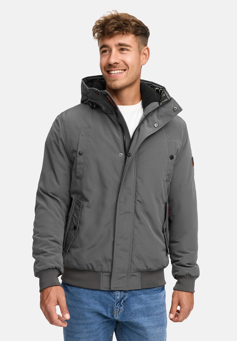 Chaqueta acolchada gris con capucha, que presenta un cierre frontal con cremallera, botones a presión y bolsillos laterales. Tejido texturizado con puños y dobladillo de canalé.