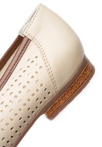 Béžová kožená nazouvací bota s perforovaným svrškem, hnědým lemováním a nízkým dřevěným podpatkem s texturou.