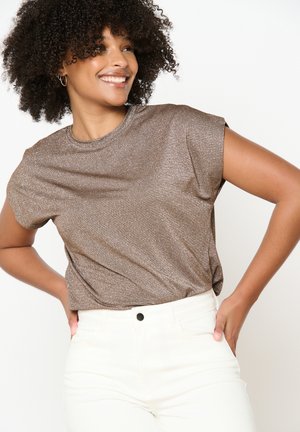 Top marrone a maniche corte realizzato in tessuto scintillante con scollatura rotonda, abbinato a pantaloni bianchi a vita alta. Texture liscia, vestibilità casual.