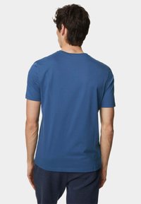 Korte mouwen blauwe katoenen t-shirt met een ronde hals, een gladde textuur en een normale pasvorm, vanachter weergegeven zonder zichtbare logo's.