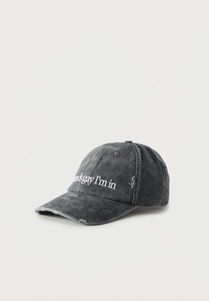 Șapcă de baseball neagră, uzată, cu detalii deteriorate și text brodat alb pe panoul frontal, care spune „sounds gay I’m in”.