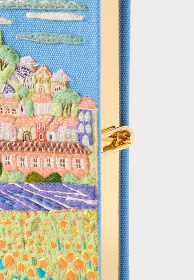 Κάλυμμα σημειωματάριου κεντημένο σε μπλε χρώμα, με μια λεπτομερή τοπίο που απεικονίζει ζωντανά σπίτια, πράσινα φ�υτά και έναν ποταμό, συμπληρωμένο από μια χρυσή πόρπη.