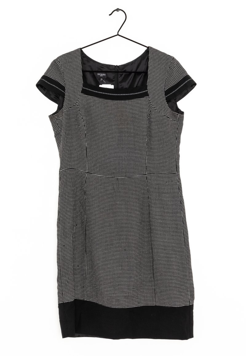 Robe à carreaux noir et blanc avec manches courtes, encolure carrée et ourlet noir uni. Le tissu a une texture lisse avec une silhouette ajustée.