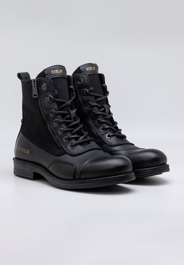 Schwarze Stiefeletten aus einer Kombination von Leder und Textilmaterialien, mit Schnürsenkeln und einem Reißverschluss an der Seite für den Verschluss, die ein robustes Design aufweisen.