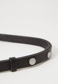 Cintura in pelle nera con superficie testurizzata, dotata di bottoni a pressione in metallo argentato e un design elegante e flessibile.