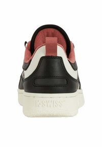 Sneaker in pelle nera con accenti beige, fodera in suede rosa e suola in gomma bianca testurizzata. Dotato di un anello sul tallone.
