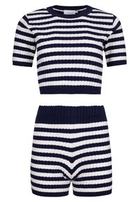 Pruhovaný pletený set v námořnické modré a bílé. Krátký rukáv crop top s žebrovanou texturou, v kombinaci s vysokými šortkami s odpovídajícími pruhy.