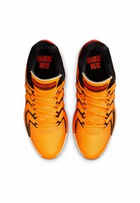 Bright orange athletic shoes with a textured surface, black accents, and distinct black lacing patterns. Features a branded inner lining.