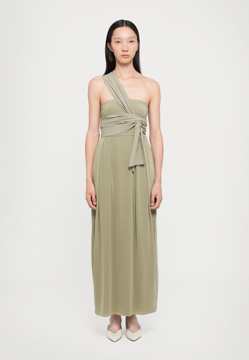 Rochie maxi de culoare verde măsliniu, având un design cu un umăr descoperit și un accent din țesătură răsucită. Textură netedă și siluetă fluidă.