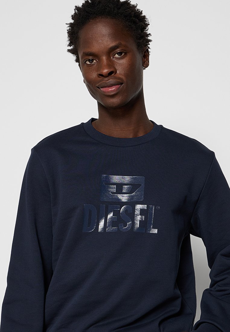 Felpa a maniche lunghe di un blu navy, realizzata in tessuto strutturato, con un logo riflettente Diesel sul davanti. Collo e polsini a costine.