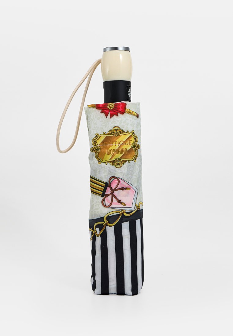 Paraguas plegado con funda a rayas negras y blancas que presenta una cadena dorada, un lazo rosa y el logotipo "Boutique Moschino", mango crema con correa para la muñeca.