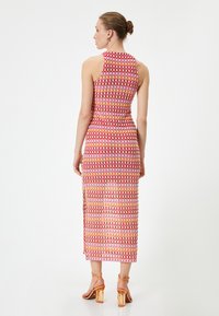 Ärmelloses Midikleid mit einem mehrfarbigen geometrischen Muster, hauptsächlich in Pink und Orange, mit einem seitlichen Schlitz und taillierter Passform.