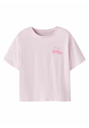 Hellrosa T-Shirt mit kurzen Ärmeln, rundem Halsausschnitt und kleinem pinkfarbenem „Adore“-Schriftzug mit Herzen auf der linken Brust.