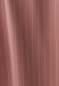 Tela rosa polvo suave con finas rayas verticales blancas espaciadas de manera uniforme y pliegues suaves.