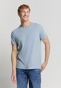 Lichtblauw gestreepte T-shirt van zachte katoen, met korte mouwen en een ronde halslijn, gecombineerd met blauwe denim jeans.