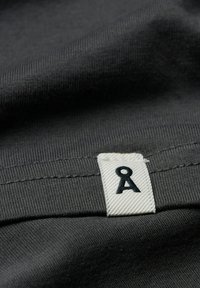Gray fabric featuring a textured surface, with a white label showing a black letter "A." The fabric appears soft and flexible.