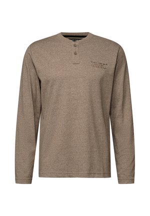 Pitkähihaista, ruskeaa henley-paitaa, joka on valmistettu teksturoituneesta kankaasta. Paidassa on kolmella napilla varustettu kaulus ja näkyvät ompeluyksityiskohdat kauluksessa ja helman kohdalla.