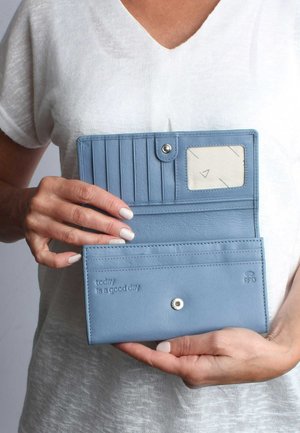 Blaues Portemonnaie aus strukturiertem Leder mit Kartenfächern, einem transparenten Ausweisfenster, Druckknopfverschluss und geprägtem motivierendem Text.