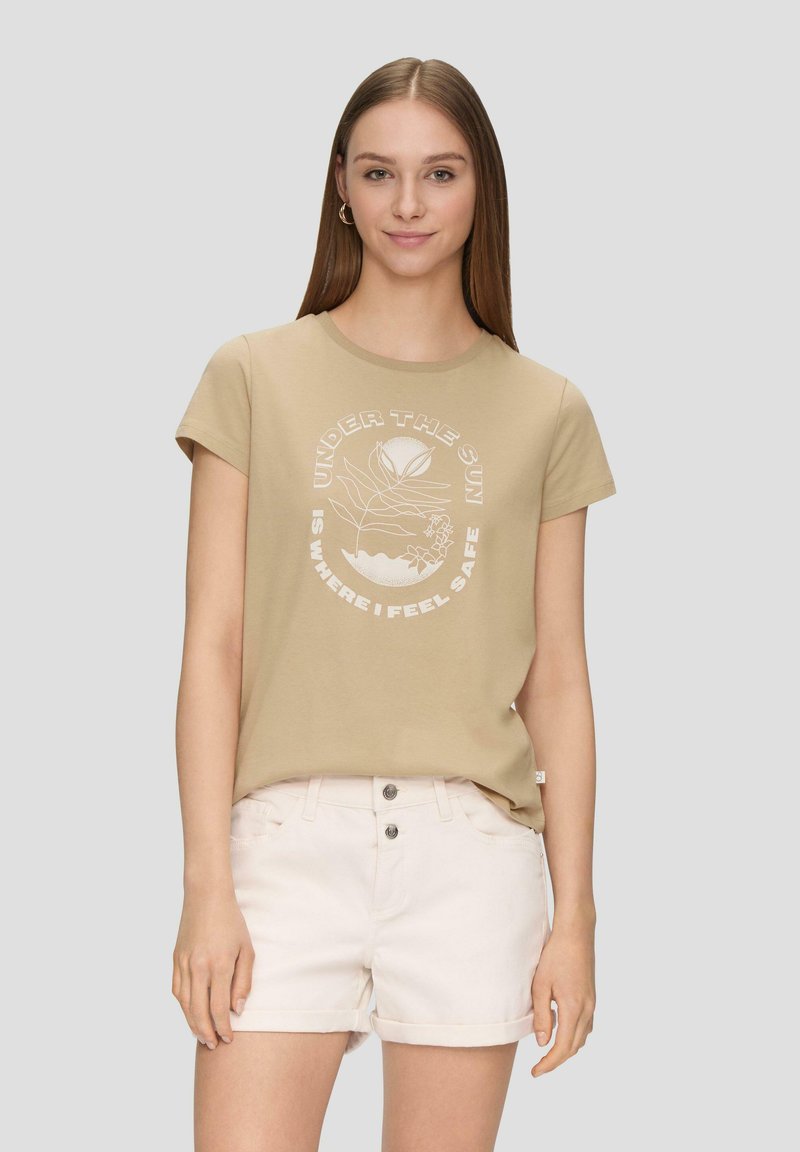 Beige katoenen t-shirt met korte mouwen, met een ronde halslijn en witte grafische tekst en bloemmotief in het midden. Draag het met lichte shorts.