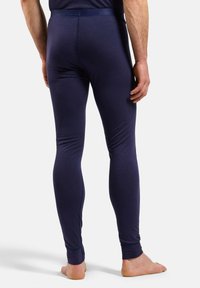 Dunkelblaue, eng anliegende Leggings aus dehnbarem Material, mit glatter Textur, einem Bund, sichtbaren Nähdetails und Knöchelbündchen.