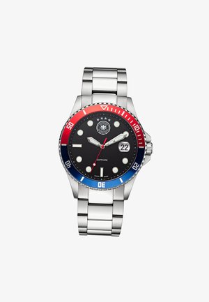Montre-bracelet en métal argenté avec cadran noir, lunette rouge et bleue, index ronds pour les heures, fenêtre de date à 3 heures et trois étoiles au-dessus du logo central.
