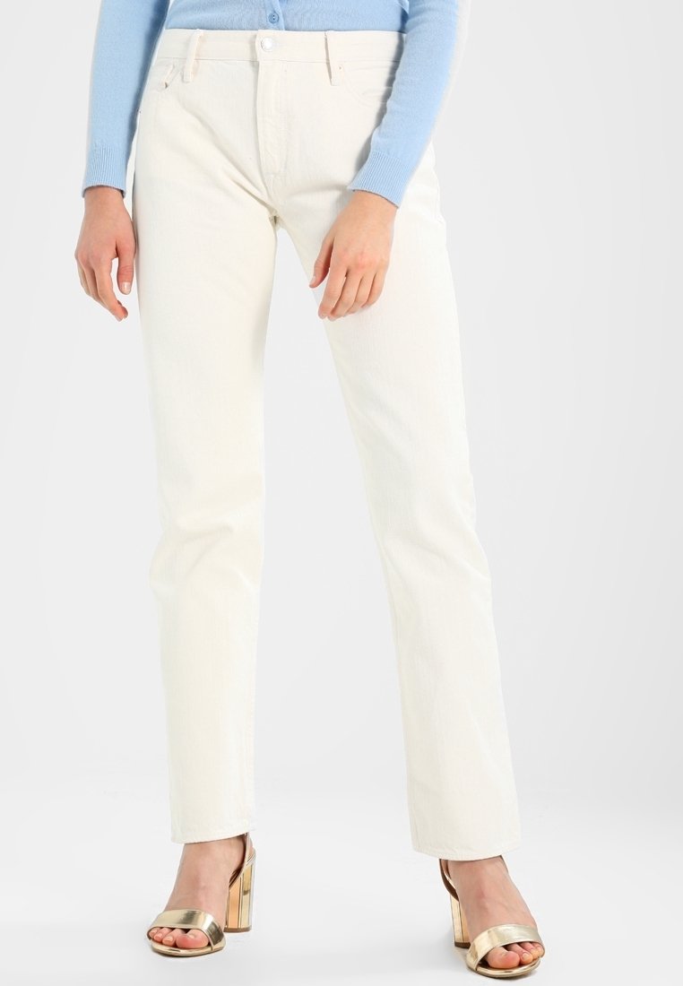Jeans blancos de pierna recta hechos de denim, con un clásico diseño de cinco bolsillos y un acabado ligeramente texturizado. Combinados con tacones metálicos.