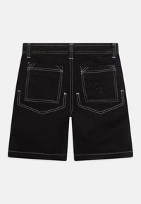 Pantalones cortos de mezclilla negra con costuras en contraste blancas, dos bolsillos traseros y un logotipo bordado en el bolsillo derecho. Diseño plano.