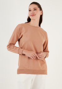 Felpa a maniche lunghe color marrone chiaro in morbido tessuto con scollatura a girocollo, polsini a costine e vestibilità rilassata, caratterizzata da un design pulito.