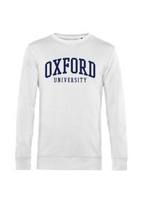 Vit långärmad sweatshirt med "OXFORD UNIVERSITY" i stora marinblå bokstäver över bröstet. Mjuk tyg med ribbad avslutning på ärmar och nederkant.