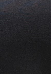 Tecido preto com uma textura suave, superfície ligeiramente brilhante e variações subtis de cor. Sem padrões ou equipamentos notáveis presentes.