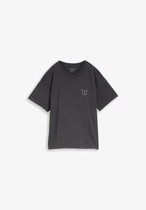 T-shirt oversize manches courtes gris foncé avec col rond et petit contour de papillon blanc sur le côté gauche de la poitrine.