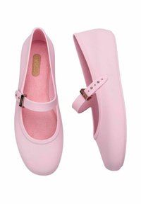 Bailarinas rosas hechas de material suave con puntera redonda, borde elástico y correa ajustable con hebilla metálica. Interior suave.