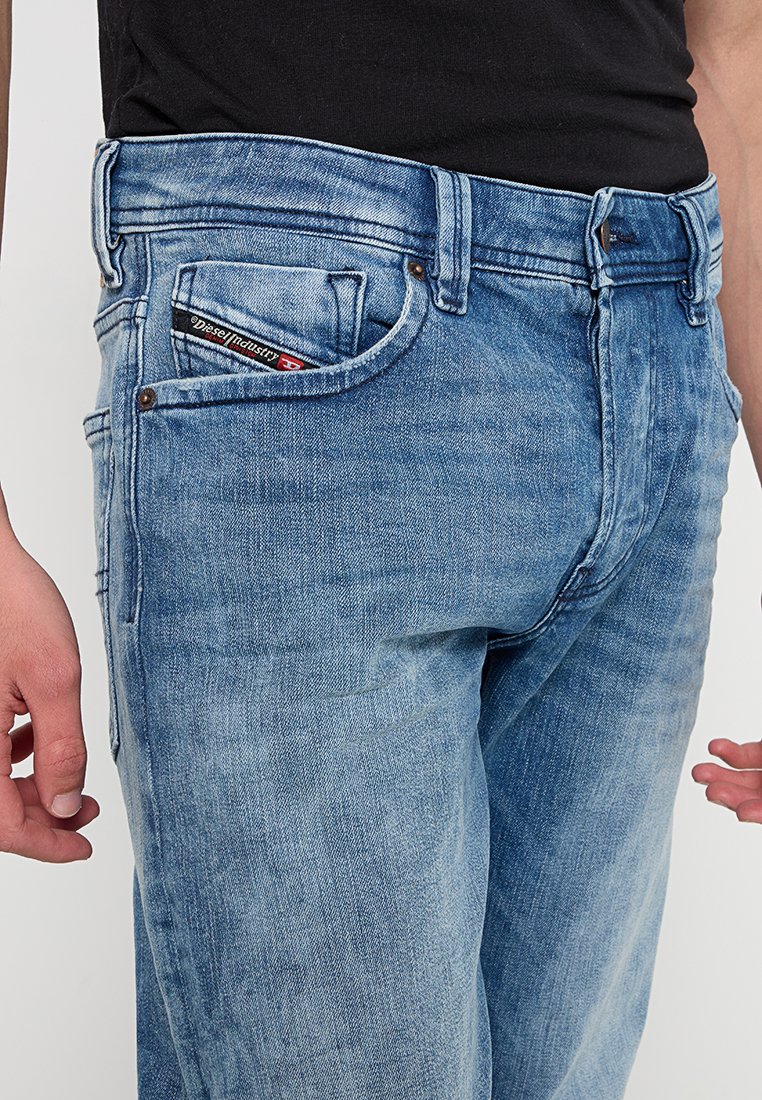 Jeans in denim blu chiaro con un classico design a cinque tasche. Presentano un'etichetta del marchio intessuta nella tasca anteriore e una leggera scoloritura sul tessuto.