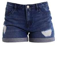 Tummansiniset farkkuhousut, joissa on kulutettu muotoilu. Ominaisuuksia: käänteet ja kaksi repäistyä läikkää edessä. Viisi taskua.