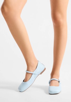 Lichtblauwe leren Mary Jane schoenen met een platte zool, vierkante neus en verstelbare band over de enkel. Glad oppervlak met minimale versieringen.