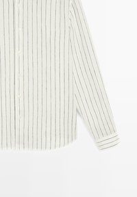 Wit overhemd met lange mouwen, fijne zwarte verticale strepen en knoopmanchetten, plat gelegd op een witte achtergrond.