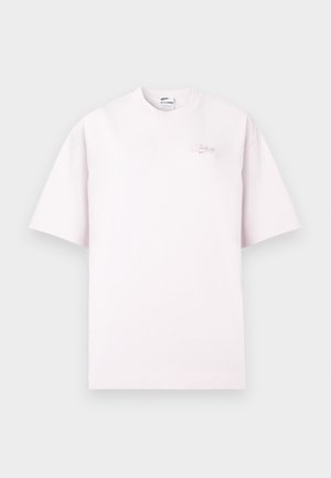 Tricou scurt cu mânecă scurtă de culoare roz deschis, cu guler rotund, având un mic text brodat în stil cursiv "Just Do It." pe partea stângă a pieptului.