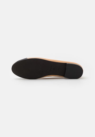 Semelle noire avec une texture lisse, semelle intermédiaire beige avec une courbe subtile. Design minimaliste sans motifs ou accents supplémentaires.