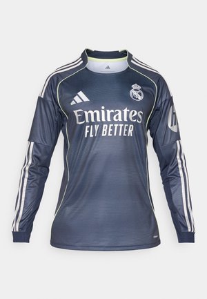 Tamsiai mėlyna vartininko marškinėliai su baltais akcentais ir grublėta tekstūra. Ant priekinės dalies yra "Emirates Fly Better" logotipas, o ant rankovių matomos trys juostelės.