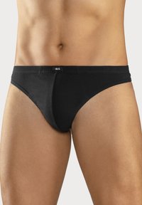 Schwarze Baumwoll-Slip mit niedrigem Schnitt, ausgestattet mit einem weichen Bund und minimaler Naht. Klassisches Design ohne Muster oder Akzente.