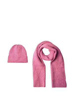 Gorro de invierno rosa de punto y bufanda larga a juego con patrón de rombos sobre fondo blanco.