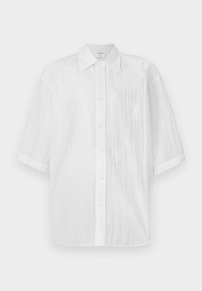 Hvit kortermet skjorte med knapper, lettvekts med strukturert stoff, med krage og rett hem, merket med merkenavnet.