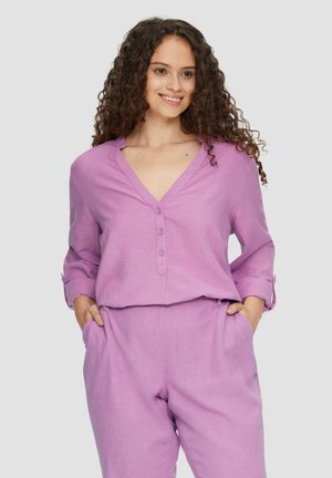 Lichtpaarse linnen blouse met een V-hals, drie knopen en opgerolde mouwen, gecombineerd met bijpassende relaxte fit broek.