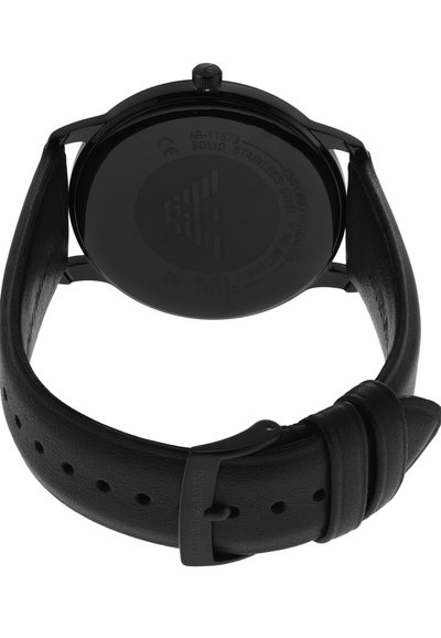 Correa de reloj de cuero negro con caja de acero inoxidable. Textura suave con esfera de reloj circular y detalles grabados en la parte posterior.