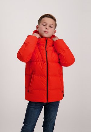 Aufgeblasene Jacke in leuchtendem Rot mit hohem Kragen und Reißverschluss, ausgestattet mit seitlichen Taschen und einem gesteppten Muster. Trägt sie mit dunklen Jeans.