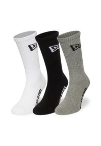 Trois paires de chaussettes de style marin : blanches, noires et grises. Texture côtelée, avec un logo sur le côté et des accents de couleur contrastante en haut.