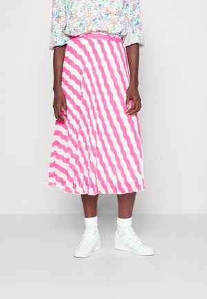 Saia midi plissada com listras onduladas em rosa e branco, com uma cintura ajustada, usada com ténis brancos e meias de cano curto.